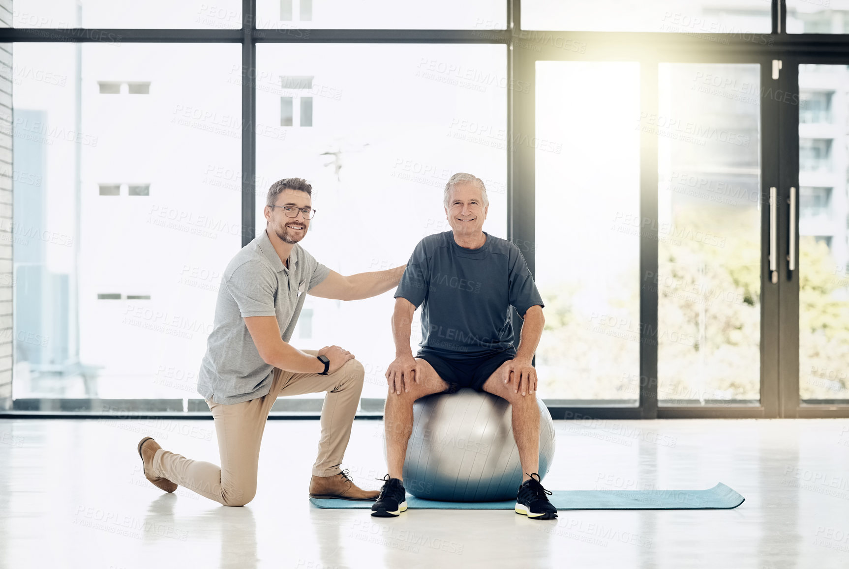 Buy stock photo Portrait, physiotherapist and old man with gym ball, smile and happy rehabilitation in senior care. Physio, consultant and elderly patient for mobility training, exercise and help in retirement.