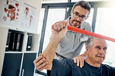 Buy stock photo Shot of a friendly physiotherapist helping his mature patient to stretch at a rehabilitation center