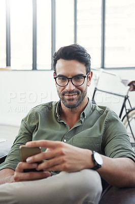 Buy stock photo Shot of a design professional using his phone while sitting in an office