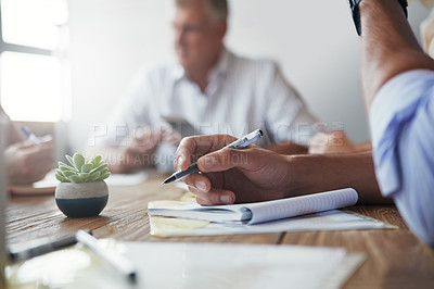 Buy stock photo Shot of an unidentifiable businessman making notes during a meeting in the office