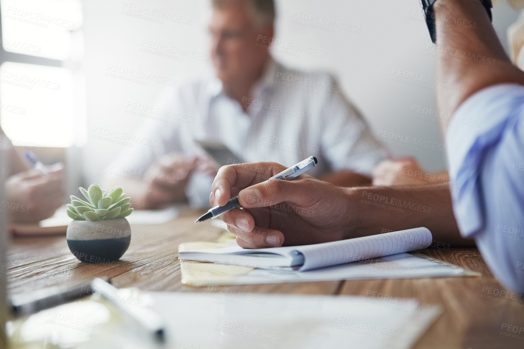 Buy stock photo Shot of an unidentifiable businessman making notes during a meeting in the office