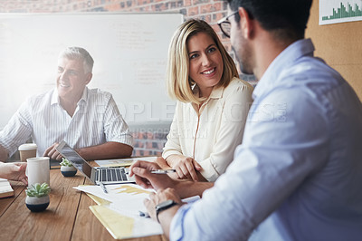 Buy stock photo Shot of a team of business colleagues discussing a project around a table in their office