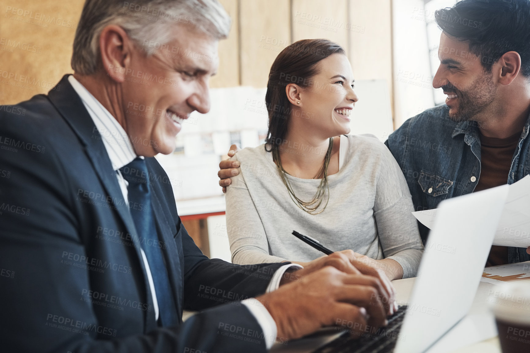 Buy stock photo Shot of a young married couple consulting with their financial advisor in his office