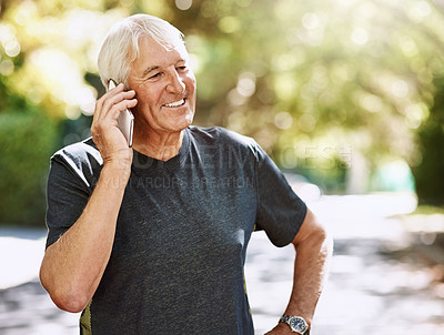 Buy stock photo Shot of a senior man talking on a cellphone while out for a run