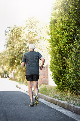 Buy stock photo Road, running and back of senior man for fitness, exercise and training outdoors with endurance for pace. Elderly athlete, runner and action with movement, wellness and health with marathon in nature