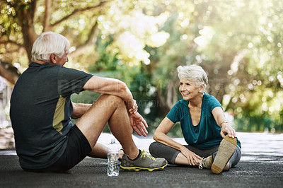 Buy stock photo Senior man, woman and sitting in street for workout, discussion for retirement with smile. Couple, exercise and together with pause for happiness on road, stretching with chat in neighborhood