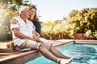Buy stock photo Shot of a happy senior man spending quality time with his daughter at the pool