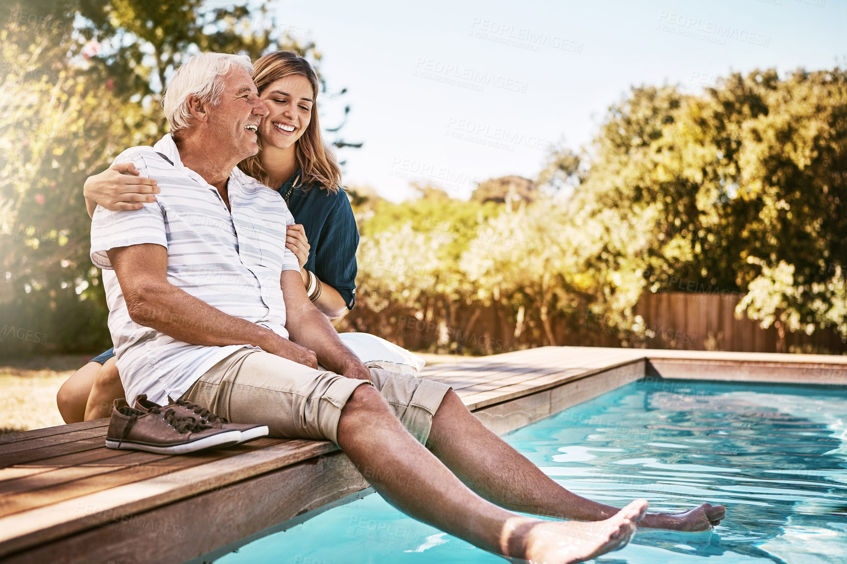 Buy stock photo Father, daughter or happiness by swimming pool for wellness, big hug or relax in garden. Senior dad, woman or outdoor with smile for bonding with peace, family with embrace or love and feet in water