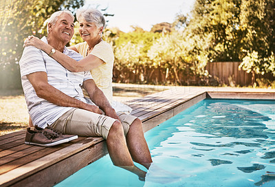 Buy stock photo Shot of a happy senior couple relaxing together by the poolside