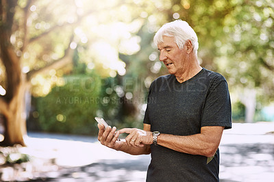 Buy stock photo Shot of a senior man texting on a cellphone while out for a run