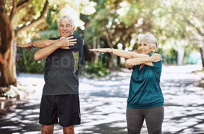 Buy stock photo Shot of a senior couple warming up before a run outside