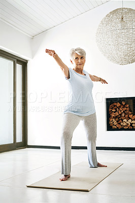 Buy stock photo Shot of a senior woman practising yoga at home