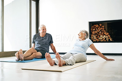 Buy stock photo Shot of a senior couple taking a break while doing yoga together at home