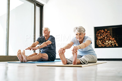 Buy stock photo Shot of a senior couple practising yoga together at home