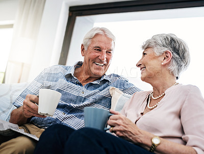Buy stock photo Shot of a senior couple relaxing on the sofa and enjoying a coffee break at home