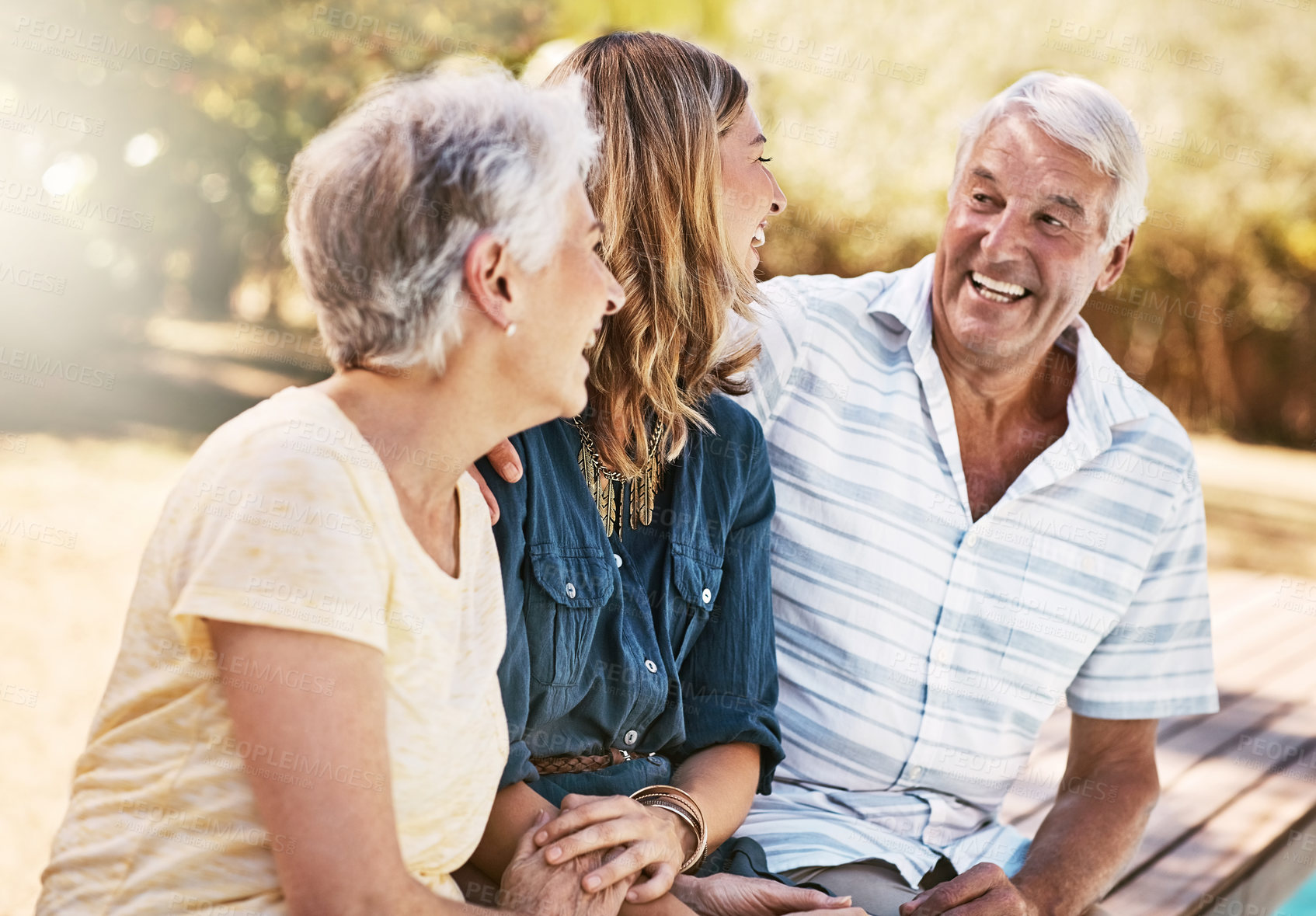 Buy stock photo Fun, laughing and parents bonding with daughter at the pool to relax together in summer. Funny, happy and senior mother  and father with a woman for quality time, peace and comic conversation