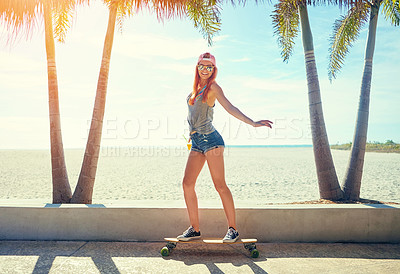 Buy stock photo Shot of a young woman hanging out on the boardwalk with her skateboard