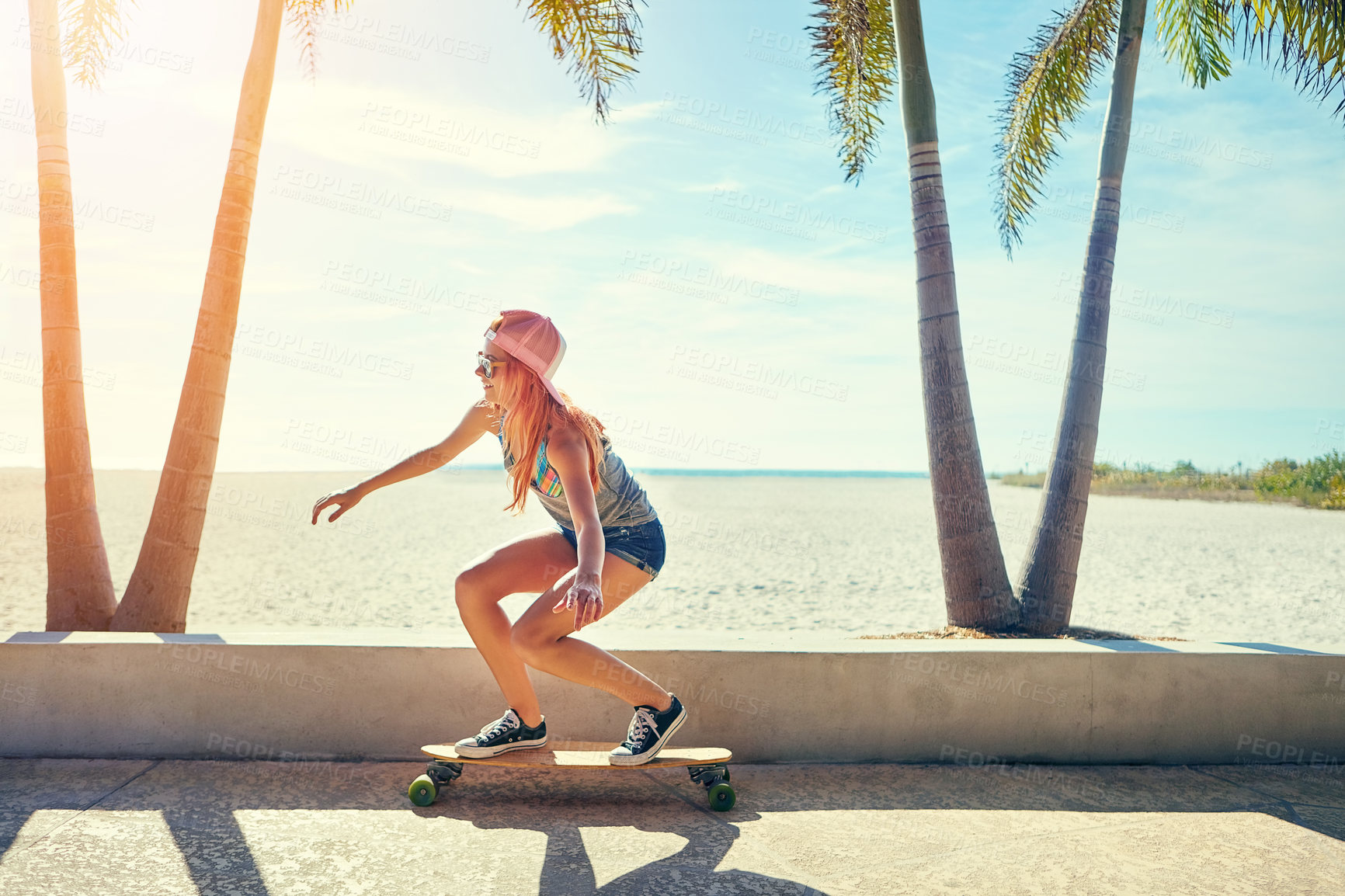 Buy stock photo Shot of a young woman hanging out on the boardwalk with her skateboard