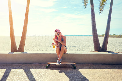 Buy stock photo Shot of a young woman hanging out on the boardwalk with her skateboard