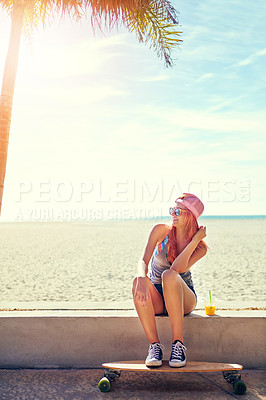 Buy stock photo Shot of a young woman hanging out on the boardwalk with her skateboard