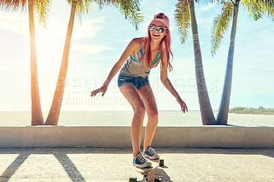 Buy stock photo Shot of a young woman hanging out on the boardwalk with her skateboard