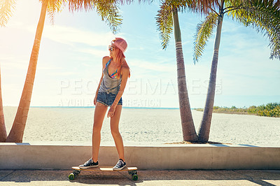 Buy stock photo Shot of a young woman hanging out on the boardwalk with her skateboard