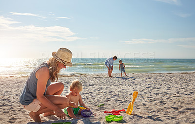 Buy stock photo Shot of a young family enjoying a summer day out at the beach