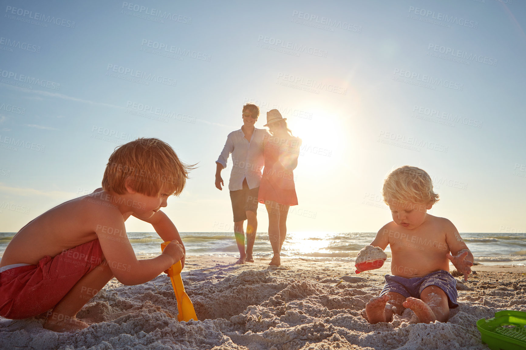 Buy stock photo Travel, family and children with sand castle on beach for holiday, summer or vacation together. Mother, father and brother siblings outdoor on tropical coast for adventure, bonding or development