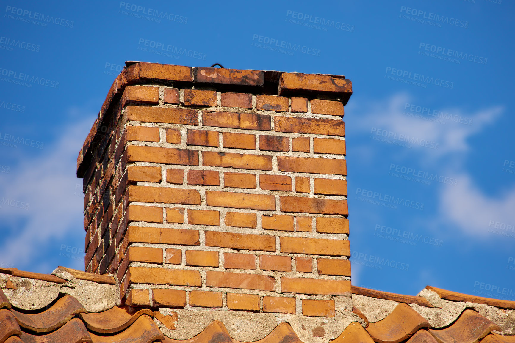 Buy stock photo Copy space with a chimney on the rooftop of a house or building against a blue sky background. Brick construction of an exterior escape chute for ventilation of air and smoke from a fireplace or oven