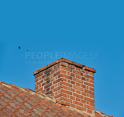 Buy stock photo Copy space with a chimney on the roof of a building against a clear blue sky background. Exterior design of a chute constructed on a rooftop for ventilation of air and smoke from a fireplace or oven