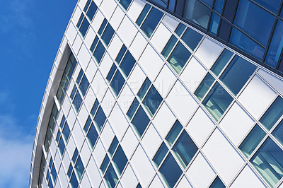 Buy stock photo Building, architecture and glass windows with blue sky below for industrial development, infrastructure or construction. Low angle, structure or architecture with exterior detail in an urban suburb