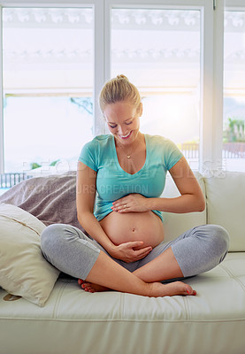 Buy stock photo Shot of a pregnant woman holding her belly at home