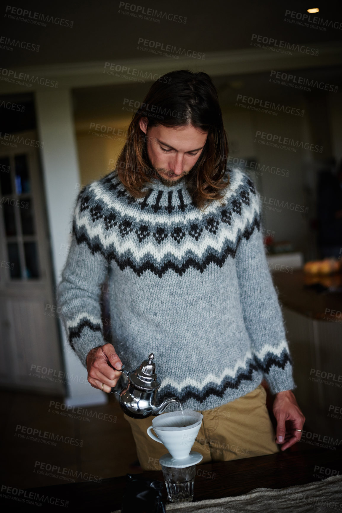 Buy stock photo Shot of a young man preparing coffee in his kitchen