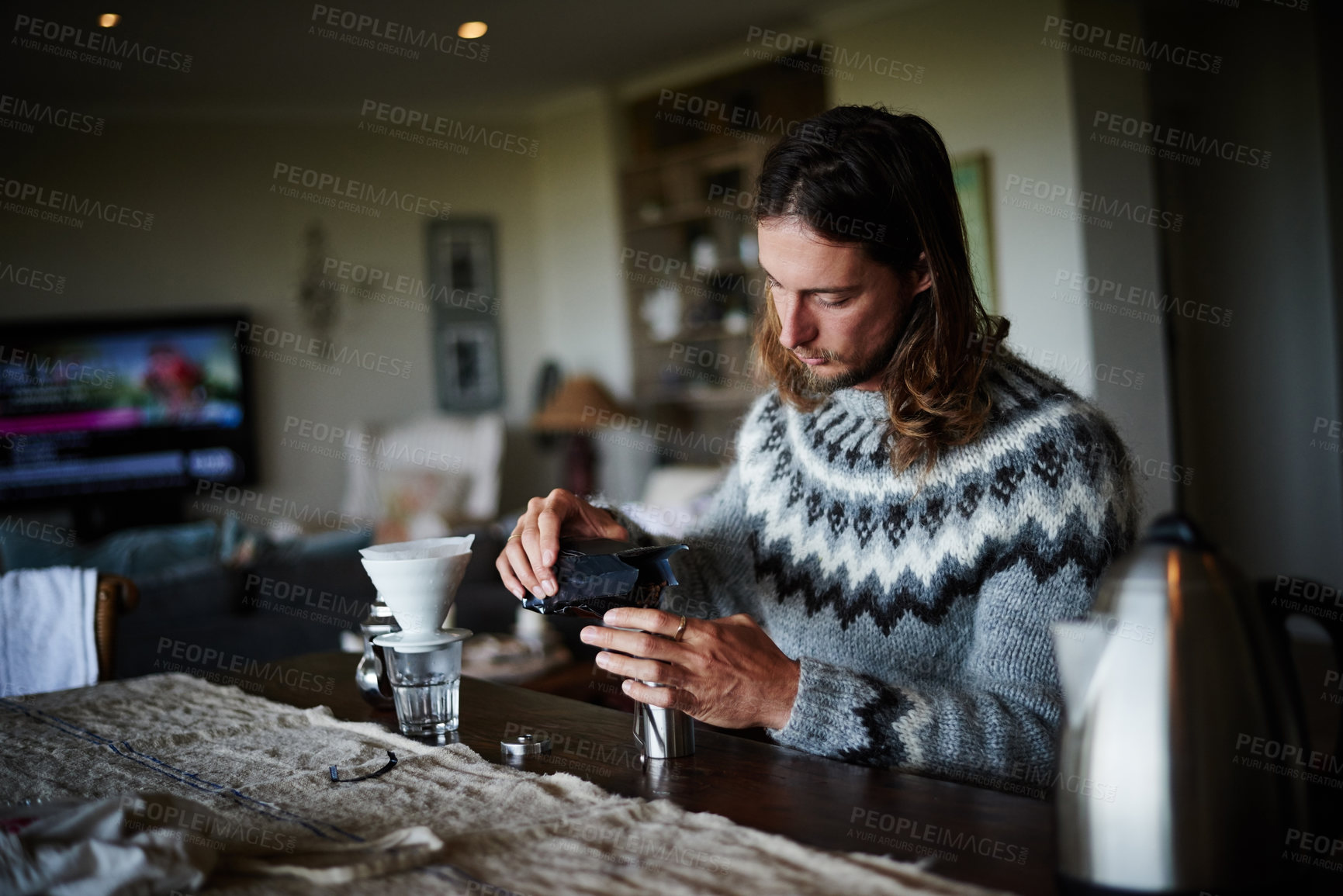 Buy stock photo Shot of a young man preparing coffee in his kitchen