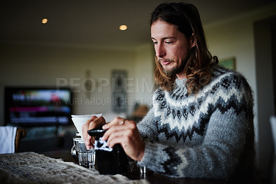 Buy stock photo Shot of a young man preparing coffee in his kitchen