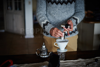 Buy stock photo Cropped shot of a man preparing coffee in his kitchen