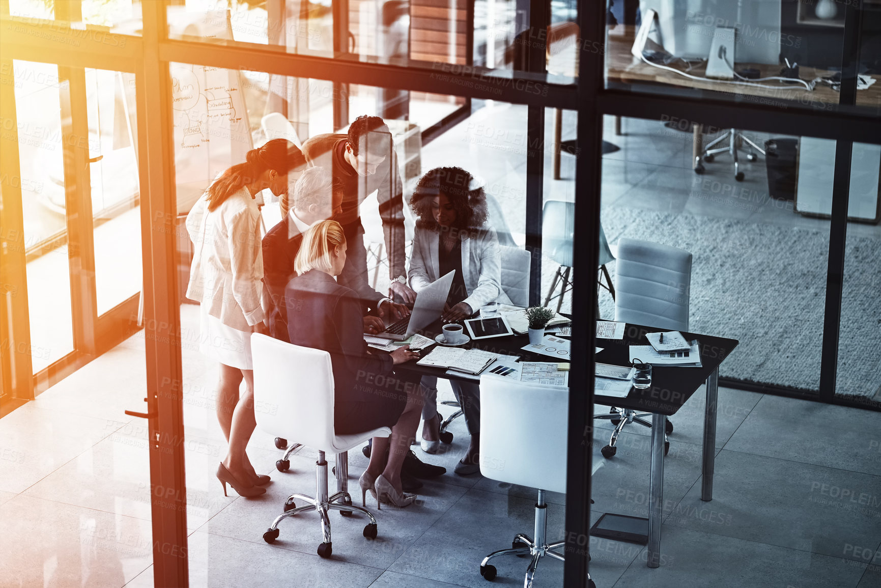 Buy stock photo Shot of a group of corporate businesspeople looking at a laptop together during a meeting in the boardroom