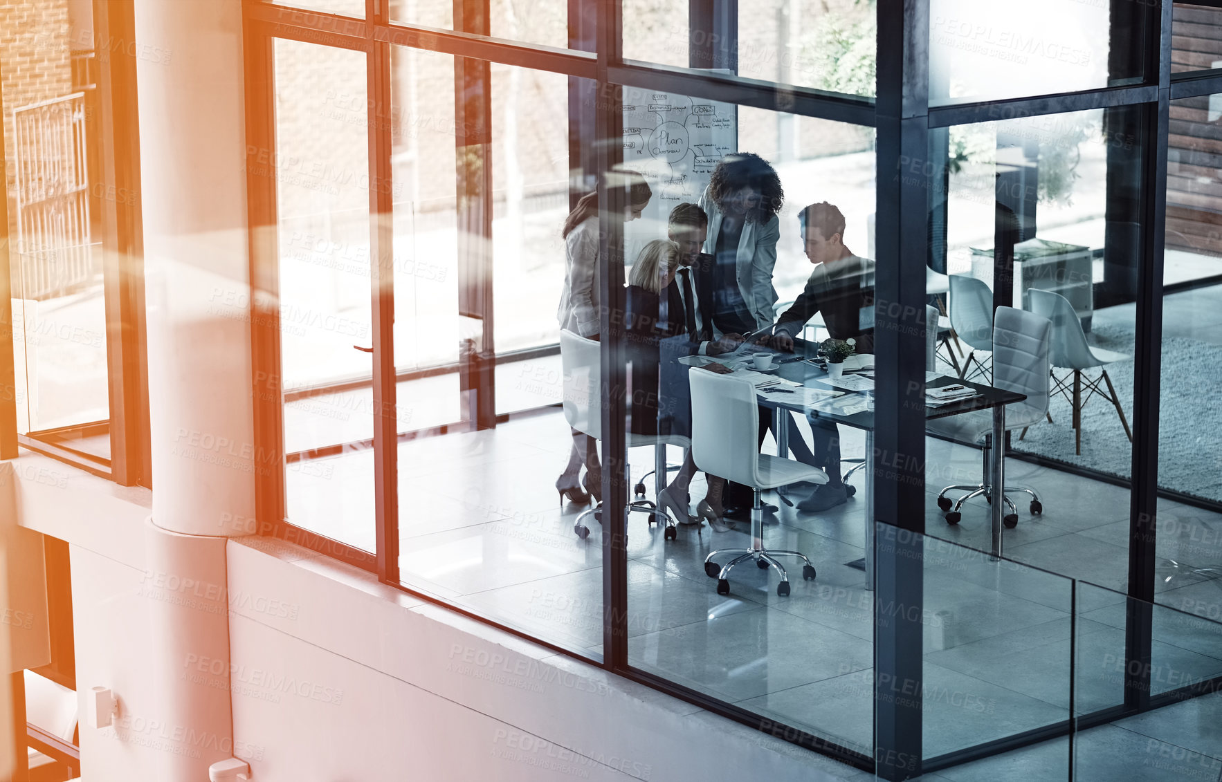 Buy stock photo Shot of a group of corporate businesspeople looking at a tablet together during a meeting in the boardroom