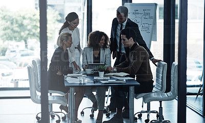 Buy stock photo Shot of a group of corporate businesspeople looking at a tablet together during a meeting in the boardroom