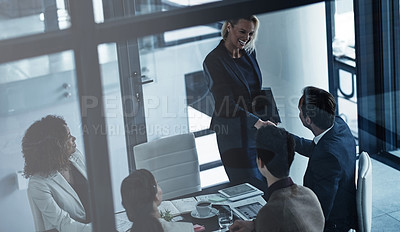 Buy stock photo Shot of two corporate colleagues shaking hands during a meeting in the boardroom