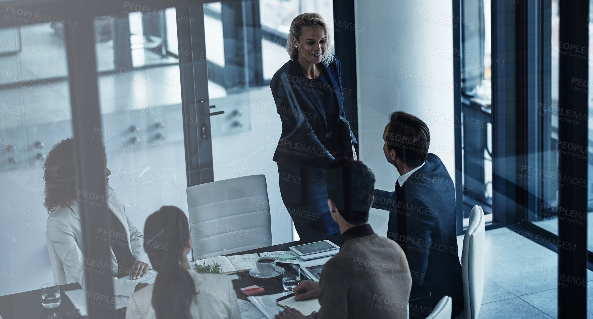 Buy stock photo Shot of two corporate colleagues shaking hands during a meeting in the boardroom