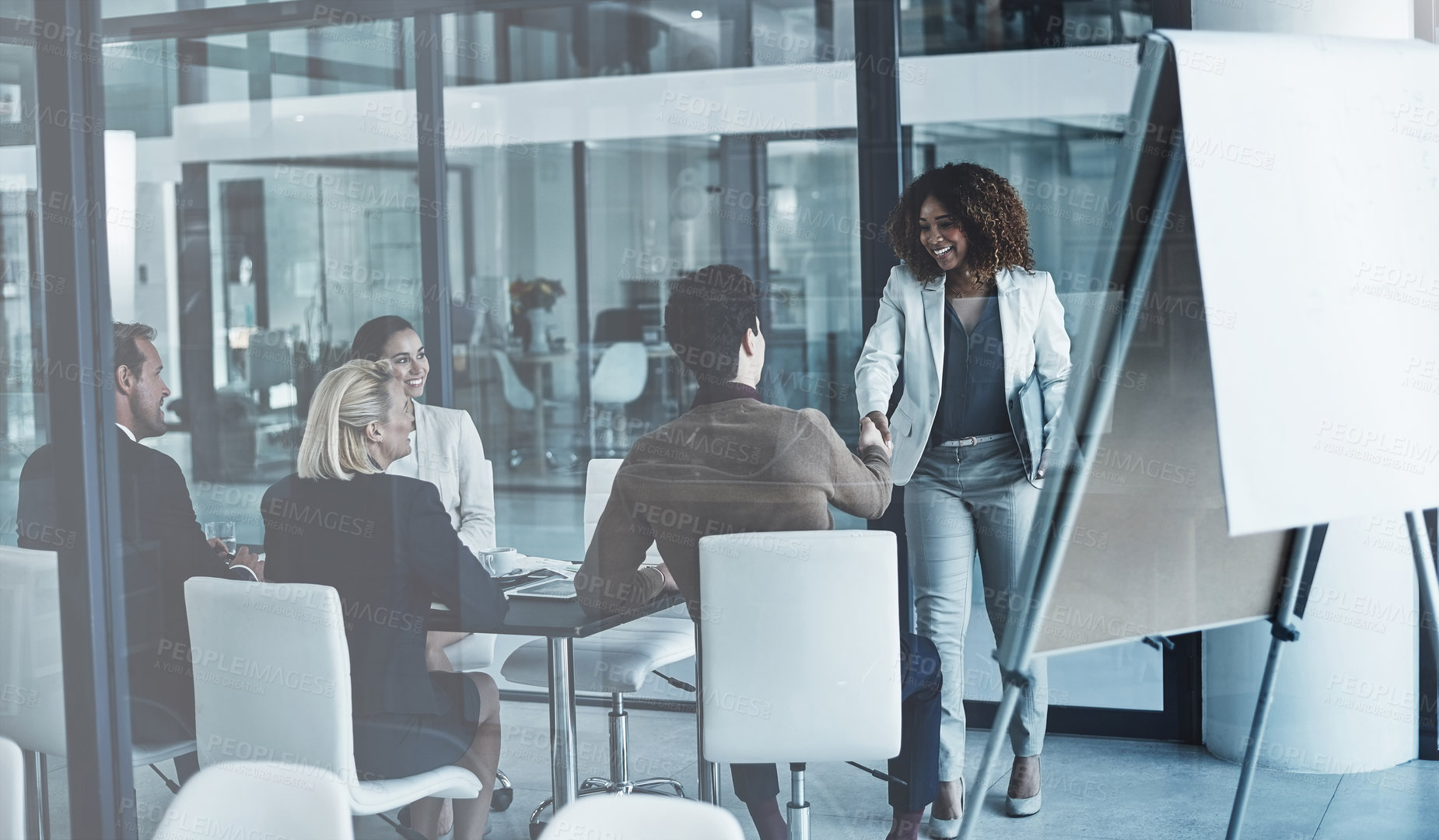 Buy stock photo Shot of two corporate colleagues shaking hands during a meeting in the boardroom