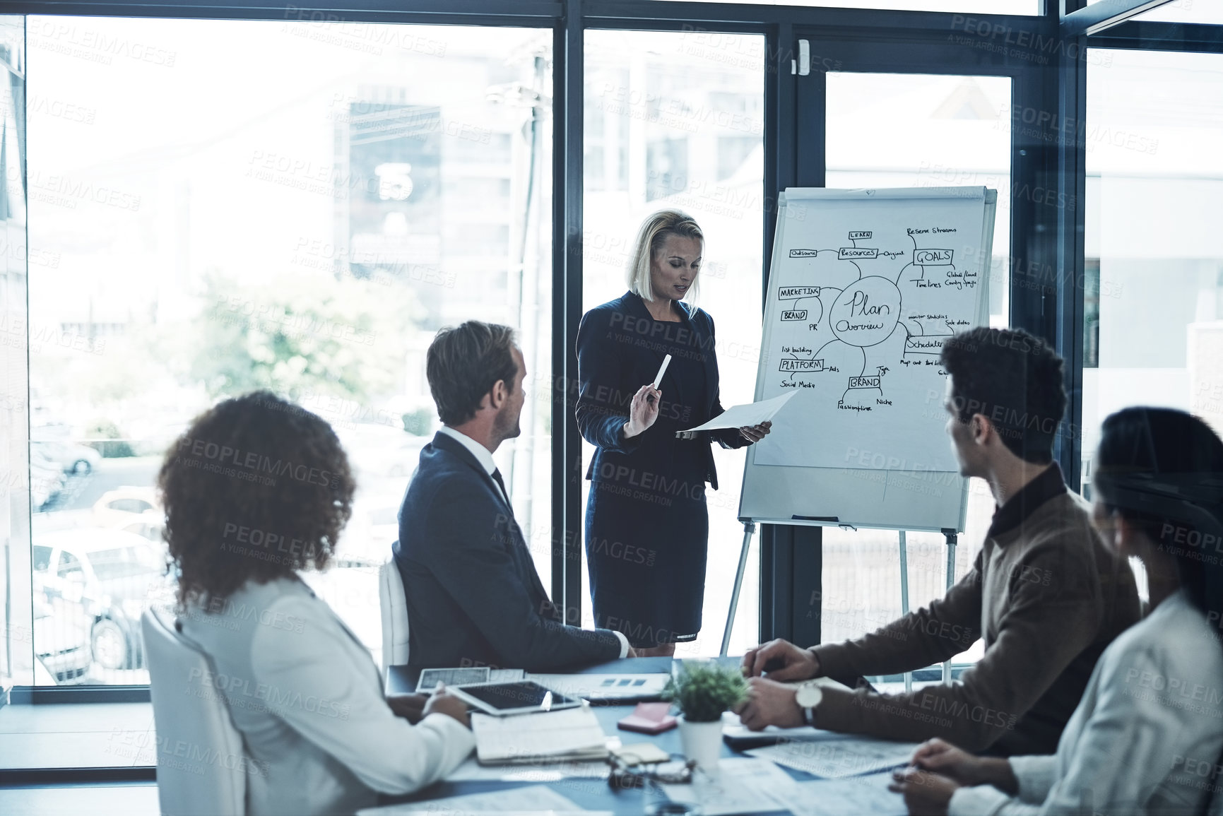 Buy stock photo Shot of a corporate businesswoman giving a presentation to her colleagues in the boardroom