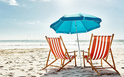 Buy stock photo Still life shot of two deck chairs under an umbrella on the beach