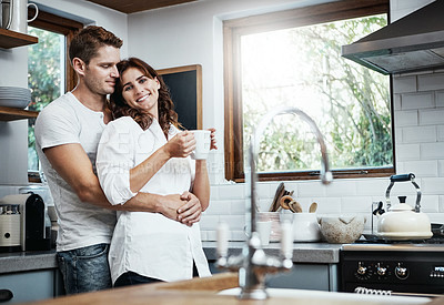 Buy stock photo Shot of an affectionate young couple standing together in the kitchen at home