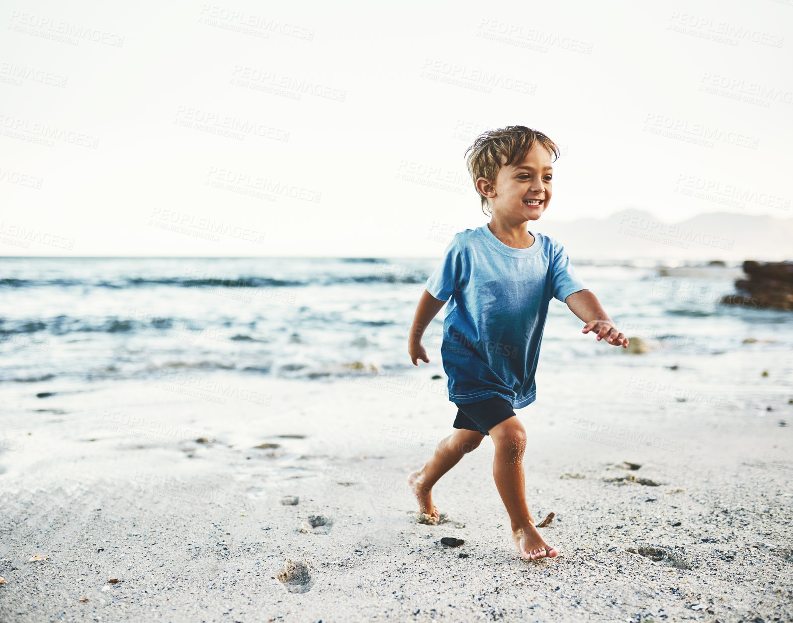 Buy stock photo Boy, walking and smile on beach with sand, feet and play for holiday, fun and development in Miami. Happy child, adventure and running by ocean with water or sunshine for travel, childhood and summer