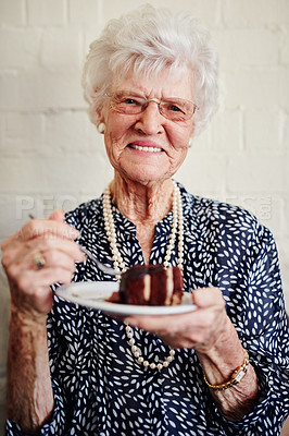 Buy stock photo Shot of a senior woman eating a slice of cake inside