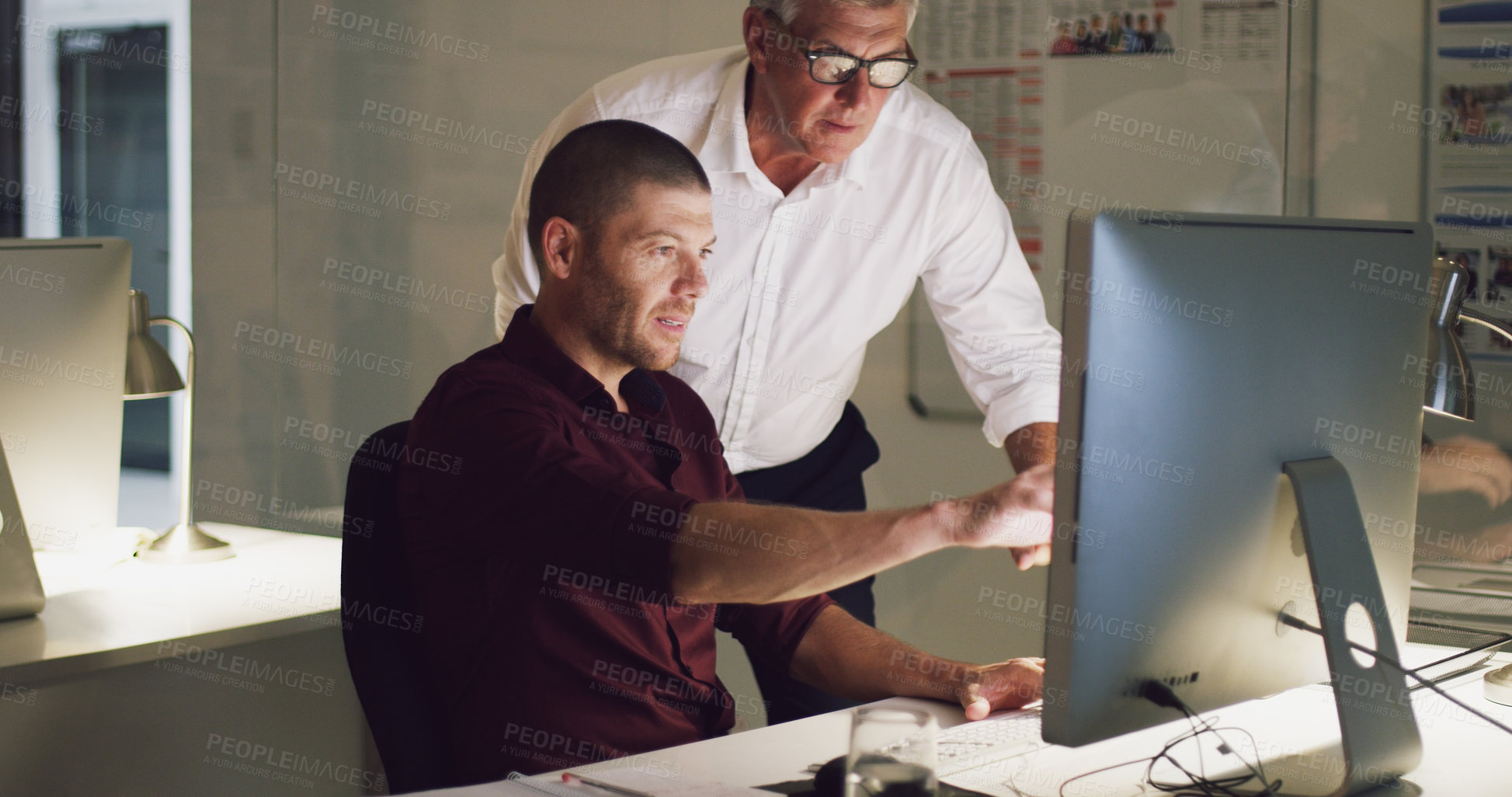 Buy stock photo Cropped shot of two businessmen working together on a computer in their office