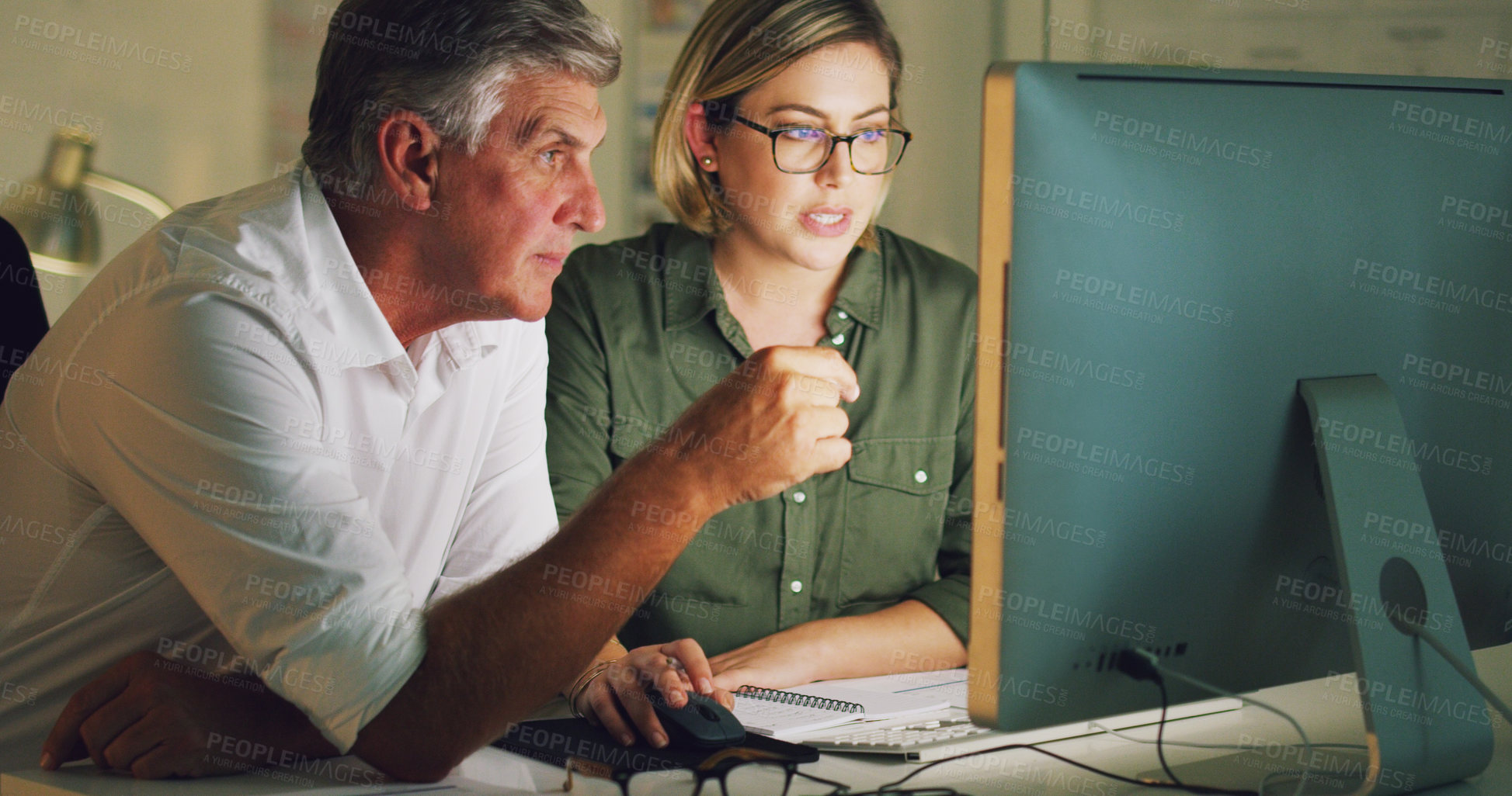 Buy stock photo Cropped shot of two businesspeople working together on a computer in their office