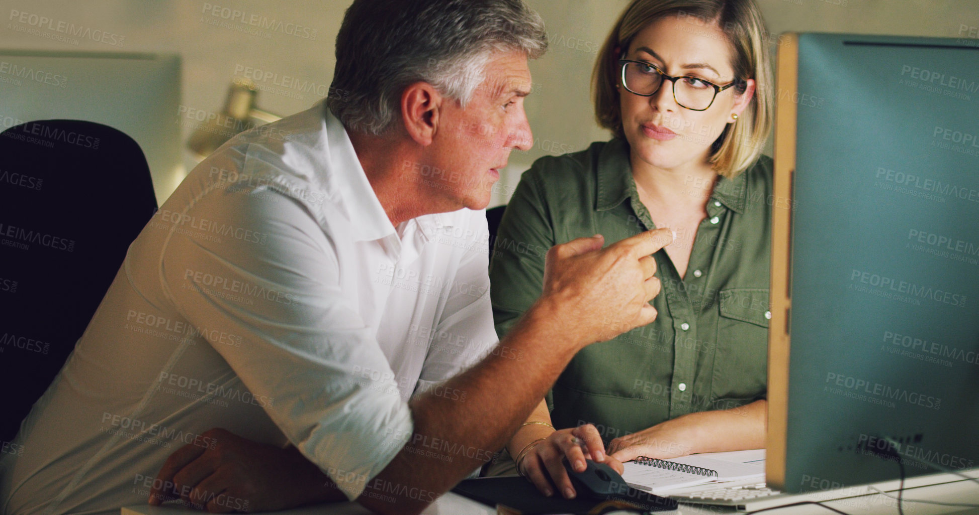 Buy stock photo Cropped shot of two businesspeople working together on a computer in their office